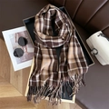Detail of soft cashmere-like scarf with classic brown plaid pattern and tassels - Coffee