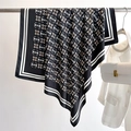 Detail of silk scarf with star print draped on rack with fashion accessories - Black