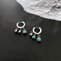 Orecchini a cerchio in argento con tre ciondoli in turchese su sfondo scuro elegante - Argento