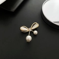 Spilla a fiocco con perle e finitura dorata su sfondo nero in stile minimalista - Spilla con Fiocco e Perla (74#XZ)