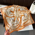 Detail eines luxuriösen Seidenschals mit Reitsportmuster, Steigbügeln und Kronen - 68x68cm / Orange