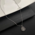 Macro shot of silver irregular coin pendant featuring a relief elephant on a split background - Elephant Pattern (05-H11) / Silver