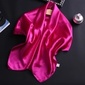 Detail of magenta satin scarf with smooth silk texture draped on black background - Rose Red