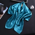 Détail du tissu en satin de soie bleu paon avec un drapé élégant et un fini brillant - Bleu Eau