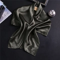 Détail d'un foulard en satin vert olive foncé avec cintre en bois sur fond noir chic - Vert Armée