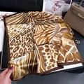 Detail of silk leopard print square scarf showing smooth texture with diverse animal patterns - Brown