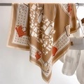 Détail du foulard en soie kaki avec imprimés mode suspendu dans une boutique - 90x90cm / Kaki