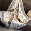 Detailed view of silk scarf with lily of the valley print on leather background - Khaki