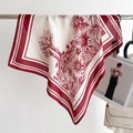 Detail of vintage floral silk scarf in burgundy and beige hanging in a lifestyle setting - Red