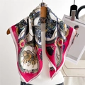 Detail shot of equestrian silk scarf featuring chain patterns and pink border on a mannequin - Red