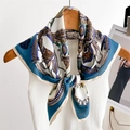 Retro silk scarf with horse carriage and chain print hanging on a white knit vest - Cyan Blue