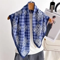 Elegant blue houndstooth silk scarf with feather patterns hanging on a rack - Navy Blue