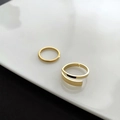 Detail of two gold-plated titanium steel rings on a minimalist white ceramic tray - US 7 / Gold (Thin Band And Wide Open Band)
