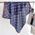 Detailed view of navy blue square scarf with animal print and brown stitched edges - Navy Animal Print Style / Navy Blue