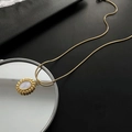 Collar dorado con colgante de nácar y cadena de serpiente sobre fondo negro - Collar De Concha De Acero De Titanio