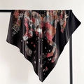 Close-up of a floral horse print silk scarf with satin finish draped on a black stand - Black
