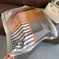 Detailed view of horse motif silk scarf with classic equestrian belts and chains patterns - 70x70cm / Brown