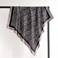 Dettaglio di un foulard in raso nero con eleganti motivi paisley argento e bordi rifiniti - Bordo grigio