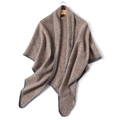 Detail view of khaki knit cashmere-like shawl with grey stitched edges on a wooden hanger - Camel