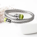 Detailansicht eines silbernen Edelstahl-Kabelarmbands mit grünen Katzenaugen-Perlen - Silberner Armreif mit grünem Katzenaugenstein