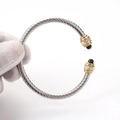 Detail of twisted cable steel bracelet with crystal settings and black bead accents - Gold-Silver White Zircon/Black Bead