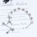 Detalle de pulsera de perlas y cuentas plateadas con colgantes de corazón, cruz y mariposa - Cadena de Plata Perla Blanca