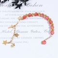 Detalle macro de pulsera con piedras de cristal rosa y colgantes dorados - Cadena de Oro Cuenta de Explosión Roja