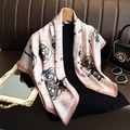 Pink camellia floral silk scarf draped elegantly on a display stand with accessories - Pink