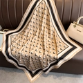 Detail of premium satin square scarf with geometric L-pattern draped on leather sofa - 90x90cm / Khaki
