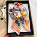 Foulard quadrato in seta rosa con motivi floreali e geometrici su vassoio - Rosa
