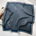 Carré de soie de 70cm à motif géométrique bleu foncé avec bordure rayée sur une table blanche - Bleu