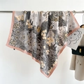 Detail of silk scarf with floral sun patterns displayed in a high-end fashion boutique - Pink Edge (FN189-1)