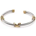 Detail eines zweifarbigen Kabeleisen-Armreifs mit goldenen X-Motiven und C-Öffnung - Gold & Silber