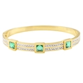 Golden titanium steel hinged bangle featuring emerald green square stones and pavé crystals - Gold Green Zirconia