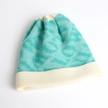 Detalle de gorro de punto azul y crema con patrón de jacquard y borde doblado para invierno - Cian