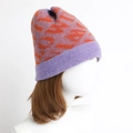 Detail of the chunky knit pattern and purple-orange contrast on the warm winter beanie - Purple