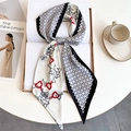 Close-up of printed silk-like scarf with equestrian chain motifs on lifestyle background - Black White Red Geometric Horsebit (LE-253)