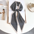 Close-up of a black and white geometric silk scarf tied elegantly on an open book - Black White Intertwined Geometric (LE-258)