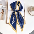 Detail of blue printed silk scarf with horse patterns on book with coffee cup - Navy Yellow Edge Running Horse Paisley (LE-260)