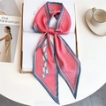 Detail of coral silk scarf tied in a bow on a book with horse and polka dot patterns - Coral Pink Running Horse Polka Dot (LE-261)