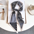 Macro detail of houndstooth silk-like neck scarf tied over an open book and magazine - Black White Grey Houndstooth Geometric Floral (LE-262)
