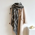 Détail d'une écharpe à carreaux gris et blanc avec franges sur un manteau en laine - 250x42cm / Gris clair