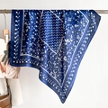 Detail eines marineblauen Seidentuchs mit elegantem weißem Blumenmuster und sanftem Faltenwurf - 70x70cm / Marineblau