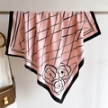 Detail of silk-texture scarf showing pink diamond lattice and camellia floral patterns - Pink