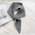 Detail of grey knitted crossover scarf showing thick texture and geometric pointed ends - Gray