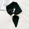 Detailed view of the black knitted scarf showing texture and unique cross-buckle closure - Black