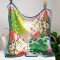 Floral print square silk scarf with blue border displayed with a white handbag - Pink and Green Floral with Lake Blue Edge (fj643-2)