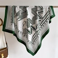 Detail of silk scarf with green and white vintage equestrian print hanging on metal bar - Dark Green