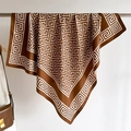 Détail d'un carré de soie marron chocolat avec motif grec géométrique sur un cintre - Chocolat