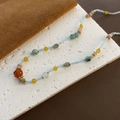 Detail of beaded necklace with strawberry quartz and natural stones on stone background - Multicolor Irregular Beads on Blue Base Style (03-K21)